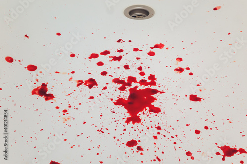 Blood draining from white bathroom basin. Bloody stains in the waterbasin hole. photo