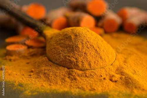 Turmeric powder and fresh turmeric (curcumin) on black background,For cooking.