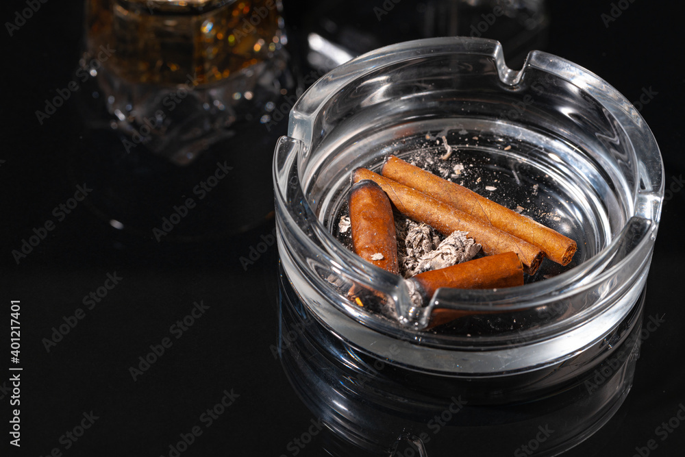 Ash tray full of cigarette butts on black background Ash tray full of cigarette butts on black background