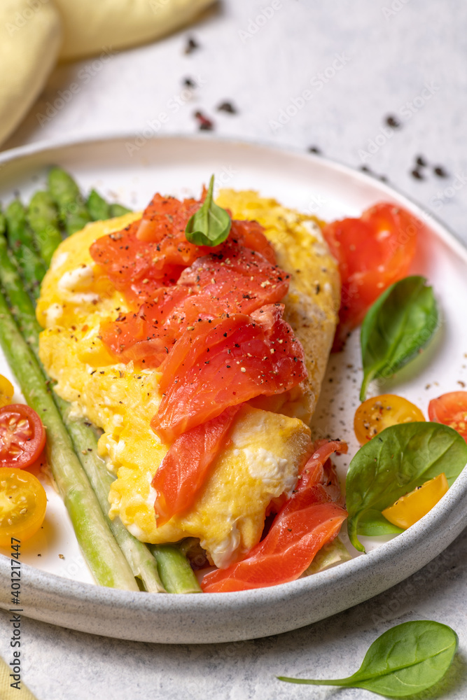 Fried eggs with green asparagus and salmon, cherry tomatoes and fresh spinach. Fried eggs with green asparagus and salmon, cherry tomatoes and fresh spinach.
