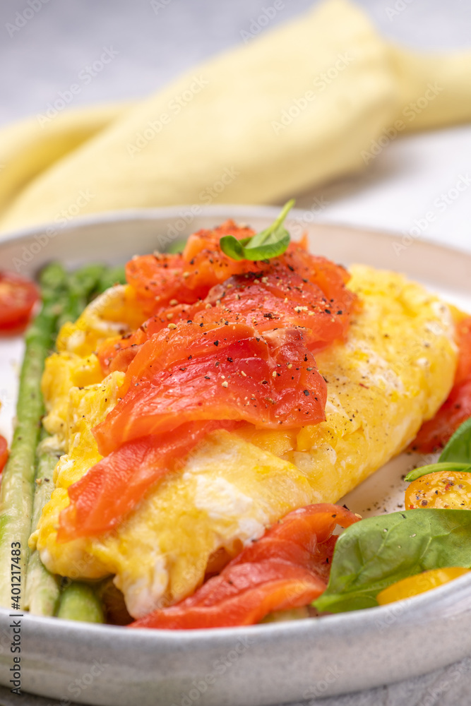 Fried eggs with green asparagus and salmon, cherry tomatoes and fresh spinach. Fried eggs with green asparagus and salmon, cherry tomatoes and fresh spinach.