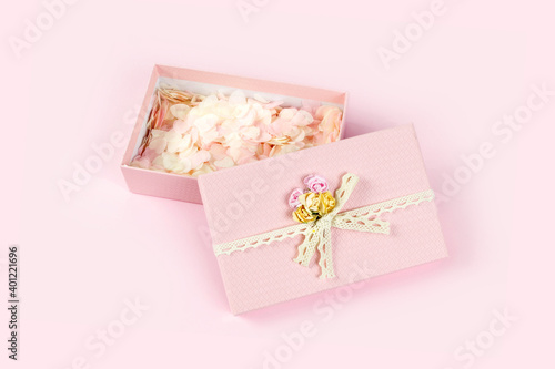 Pink gift box full of tender pink hearts of confetti on pastel background. Valentine's Day, wedding, love concept. Top view, flat lay, copy space. © Lyubov