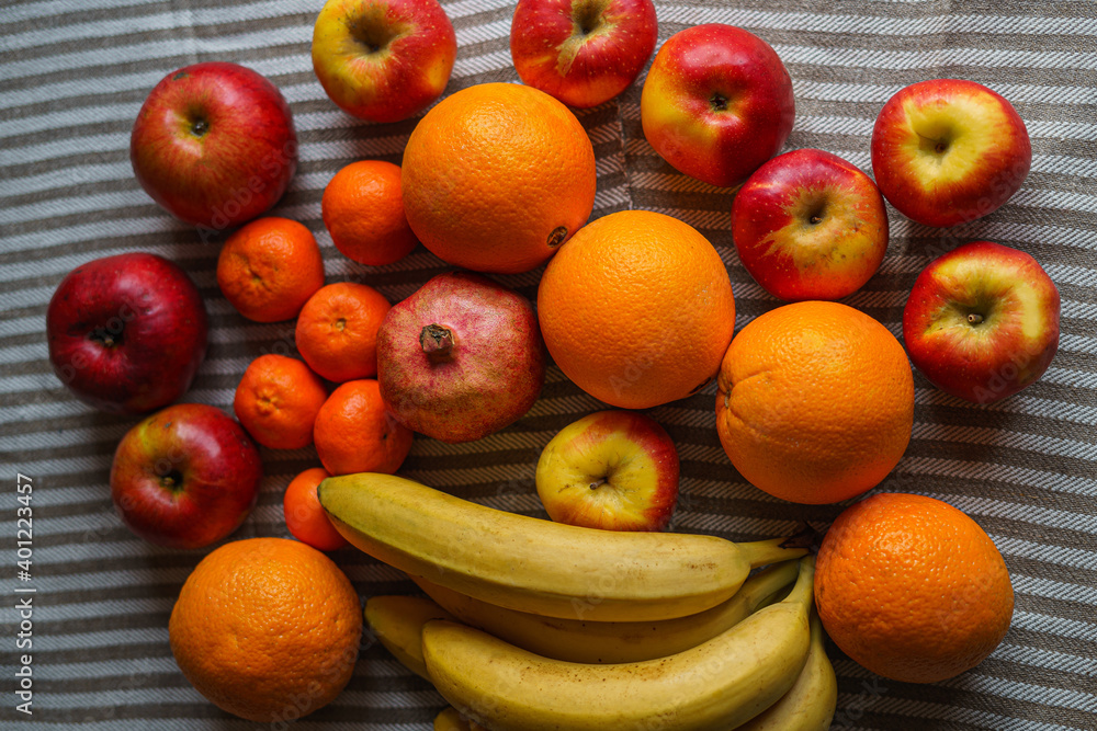 Many different fresh fruits are on the table on a mottled light canvas, top view Many different fresh fruits are on the table on a mottled light canvas, top view