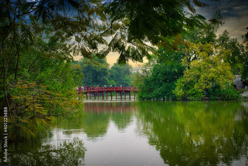 Bridge in Hanoi, Vietnam viewed from a distance surrounded by lush greenery and lake Bridge in Hanoi, Vietnam viewed from a distance surrounded by lush greenery and lake