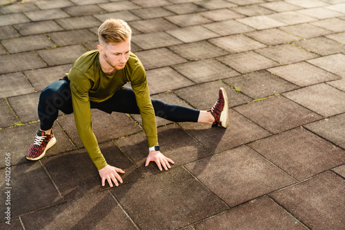 25s strong athlete stretching outdoors in sunny weather