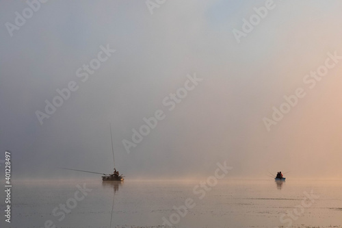 Fishing boats on the lake in the morning. Morning mist. Copy space