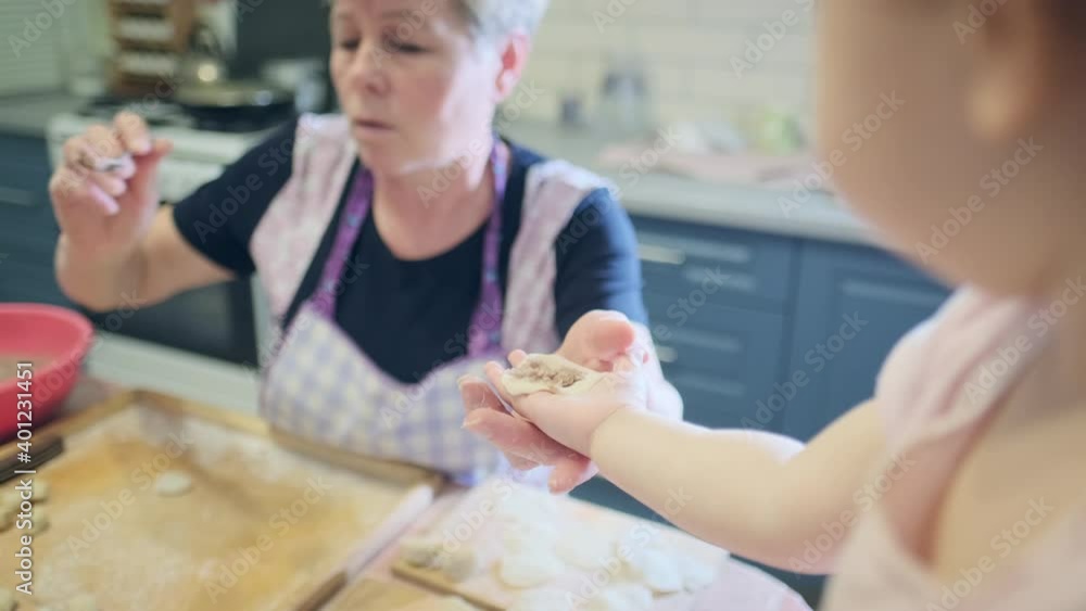 Baby cooking. Toddler girls learns pastry cooking on the kitchen with her family Baby cooking. Toddler girls learns pastry cooking on the kitchen with her family