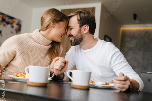 Beautiful young happy couple having breakfast