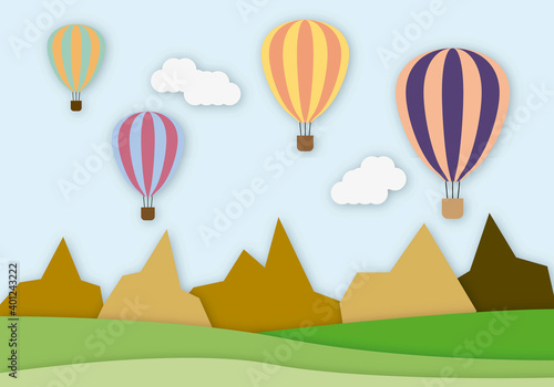 Globos aerostáticos volando por un paisaje montañoso.