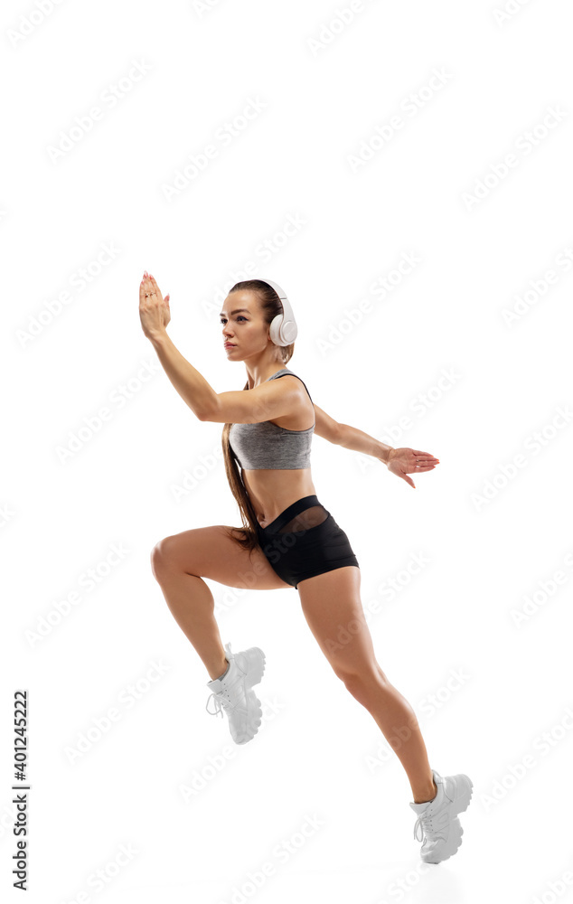 Jump up. Caucasian professional female athlete, runner training isolated on white studio background. Muscular, sportive woman. Concept of action, motion, youth, healthy lifestyle. Copyspace for ad.