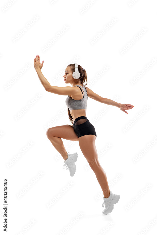 In air. Caucasian professional female athlete, runner training isolated on white studio background. Muscular, sportive woman. Concept of action, motion, youth, healthy lifestyle. Copyspace for ad.