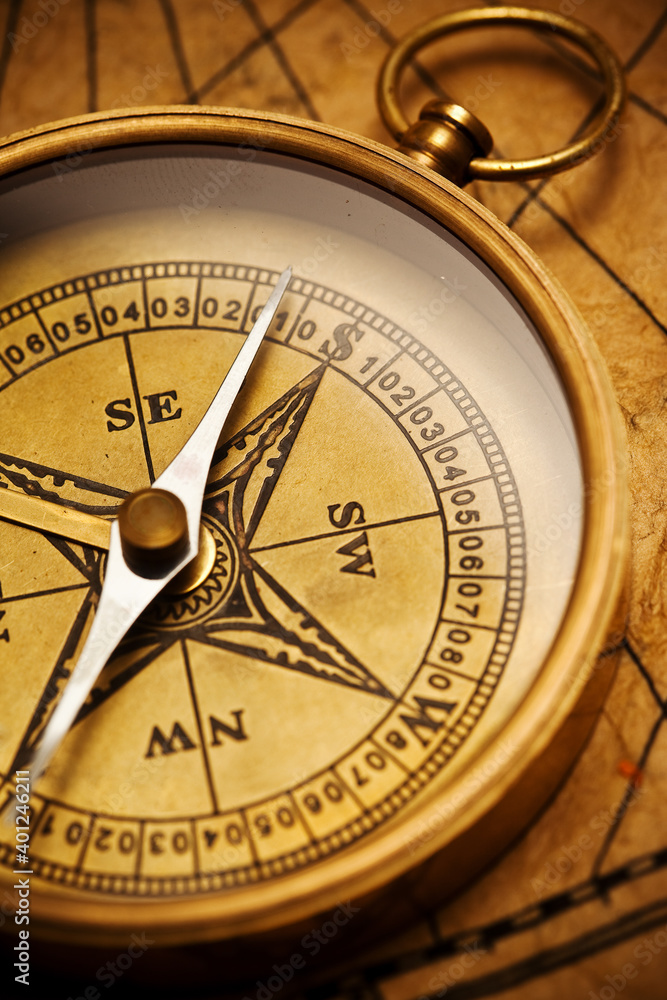 Old vintage retro compass on ancient map background. Travel geography navigation concept background.