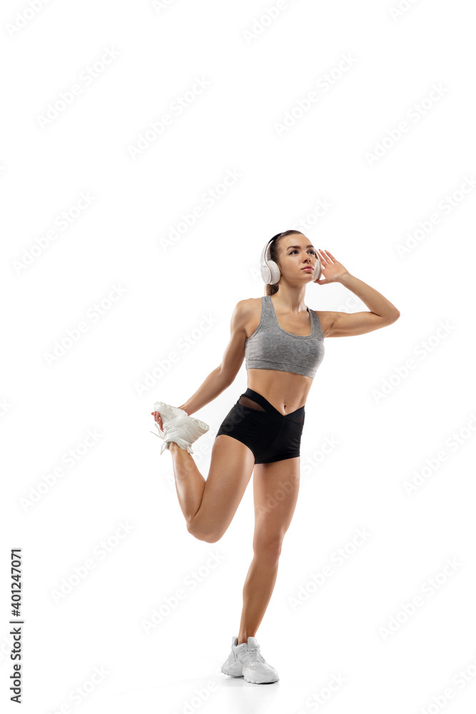Stretching. Caucasian professional female athlete, runner training isolated on white studio background. Muscular, sportive woman. Concept of action, motion, youth, healthy lifestyle. Copyspace for ad. Stretching. Caucasian professional female athlete, runner training isolated on white studio background. Muscular, sportive woman. Concept of action, motion, youth, healthy lifestyle. Copyspace for ad.