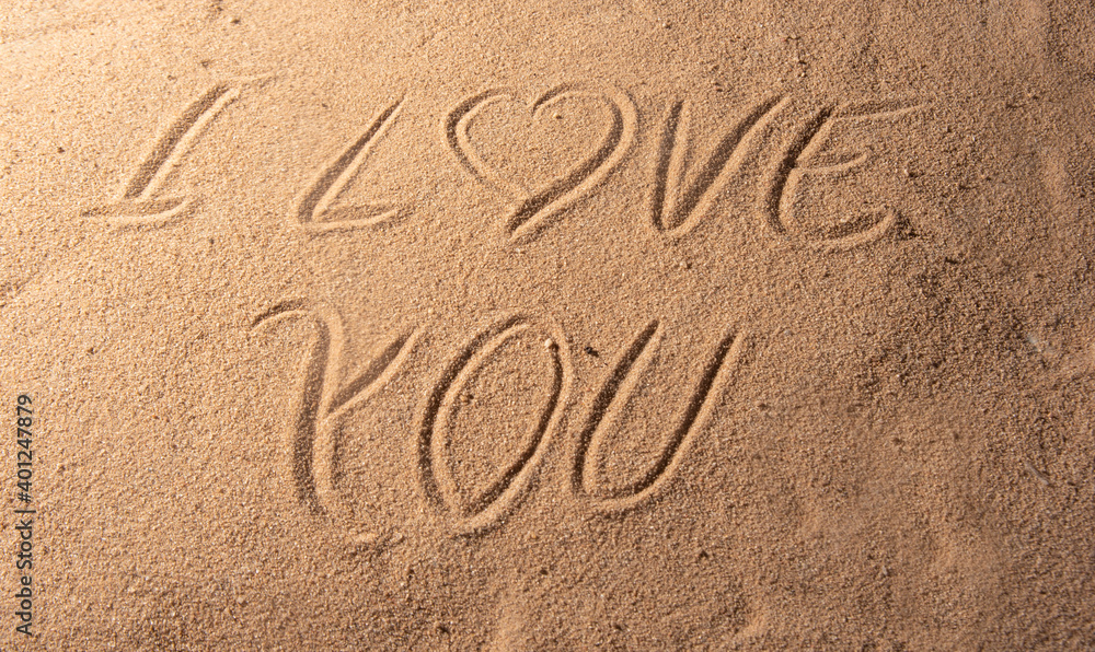 Beach sand with romantic phrases written in the sand, selective focus.