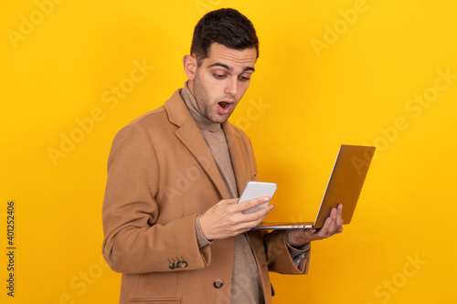 young man with smartphone and laptop isolated on background