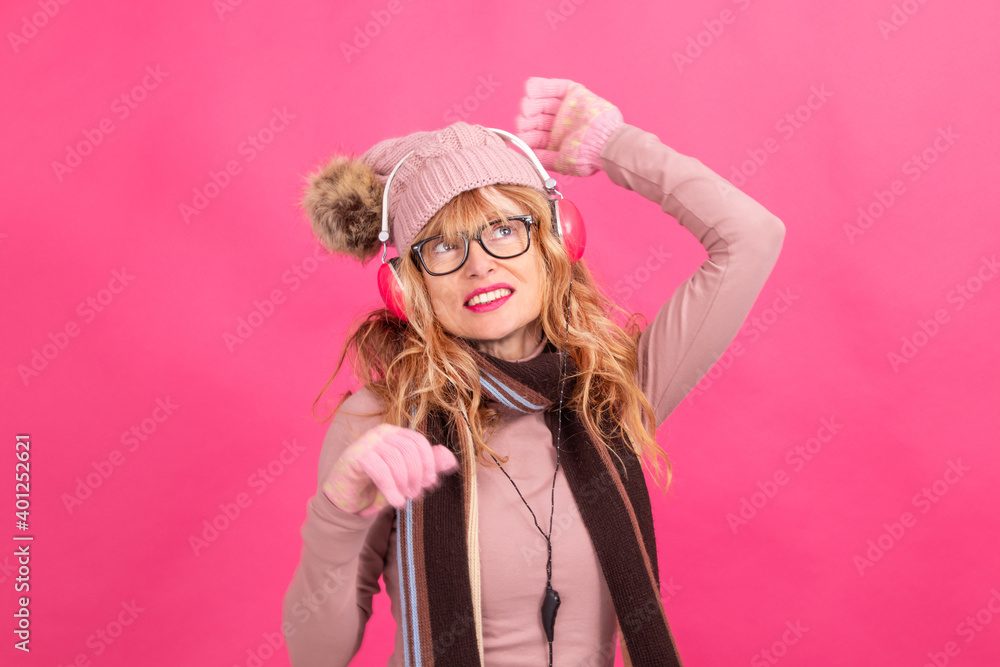 adult or senior woman dancing with headphones and winter clothes adult or senior woman dancing with headphones and winter clothes