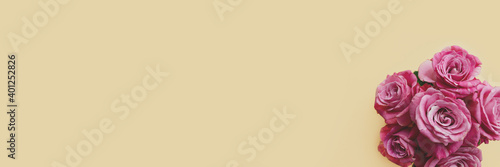 Header with bouquet of pink rose flowers on a beige background. Present for Mothers Day. Festive concept with copy space.