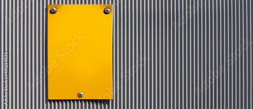 yellow plate on an industrial  fence
