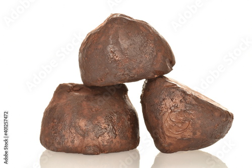 Three delicious chocolate truffles, close-up, isolated on white.