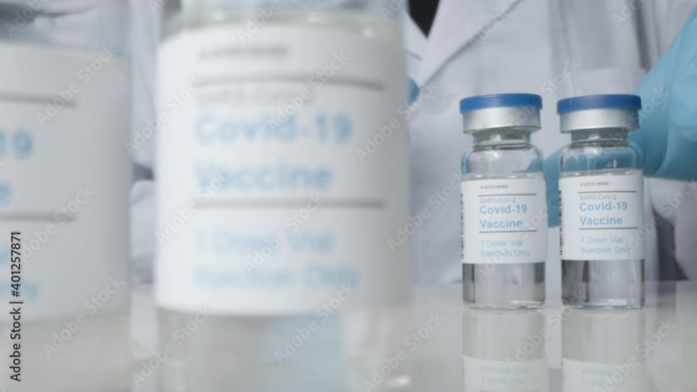 Sliding Close Up Shot Revealing Doctor Checking Vials of Covid Vaccine Sliding Close Up Shot Revealing Doctor Checking Vials of Covid Vaccine