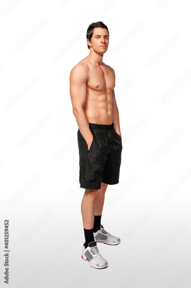 Portrait of a fit young white male athlete with short dark hair posing by himself with hands in his black short pockets in a studio with a white background. Portrait of a fit young white male athlete with short dark hair posing by himself with hands in his black short pockets in a studio with a white background.