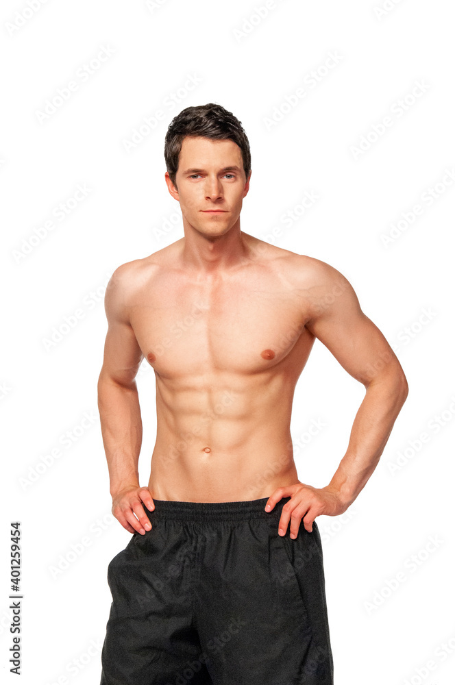 Portrait of a shredded young white male athlete with short dark hair posing by himself with hands on his hips in a studio with a white background. Portrait of a shredded young white male athlete with short dark hair posing by himself with hands on his hips in a studio with a white background.