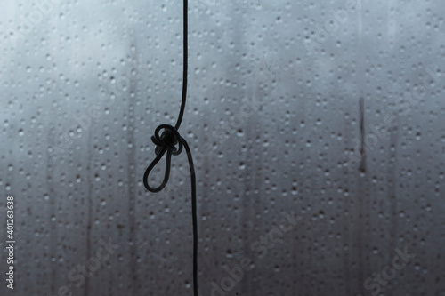 Rope knot on glass background with rain drops