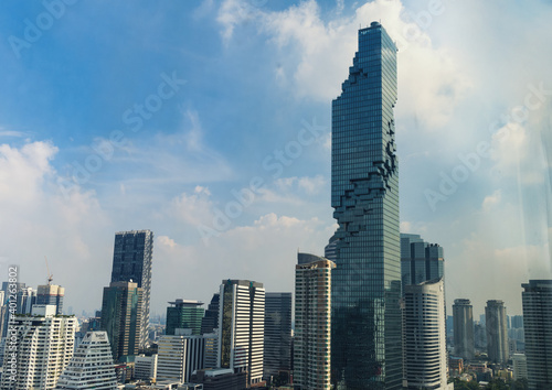 Modern city view with high buildings and towers under the blue sky.
