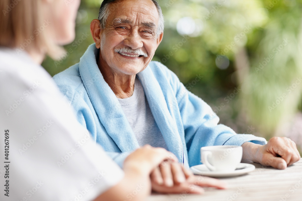 Senior man sitting at table with nurse Senior man sitting at table with nurse
