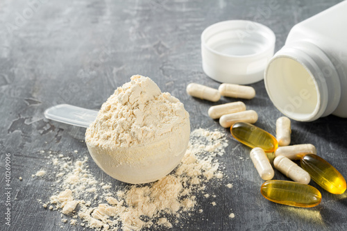 Cuadro en lienzo Scoop of whey or soy protein isolate, omega-3 capsules, white pills of bcaa, bet
