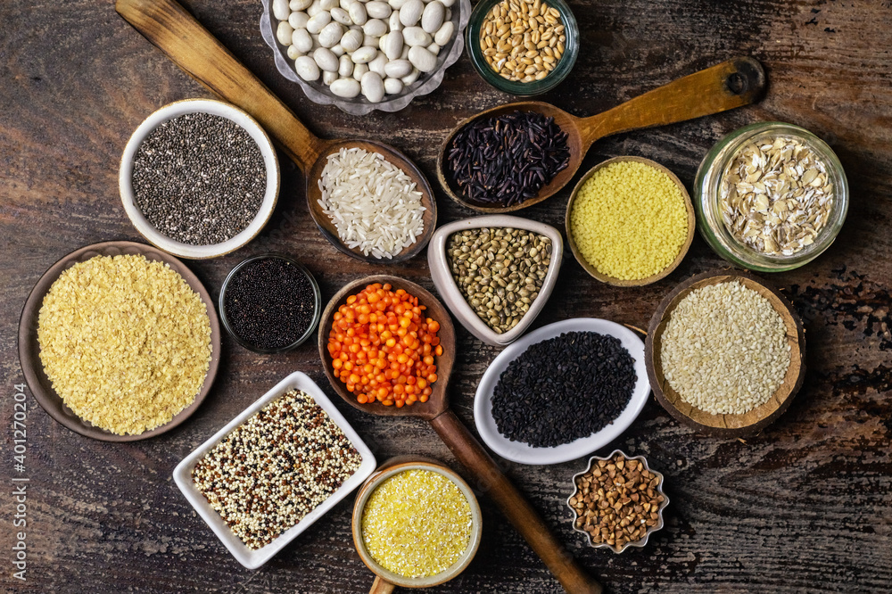 Food background of various cereals and grains in plates on a wooden table Food background of various cereals and grains in plates on a wooden table