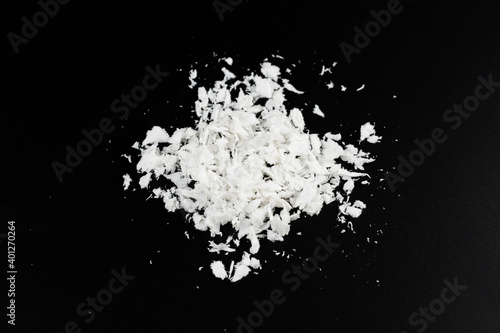 a pile of poured white artificial synthetic snow on a black background