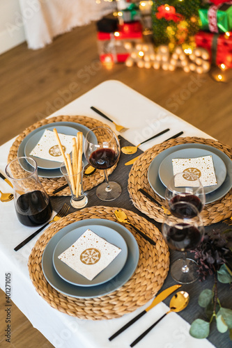 From above of ceramic plates near glasses of red wine and cutlery on table during festive event photo