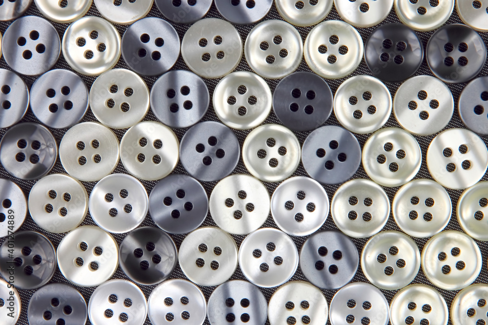 Plastic shiny buttons for clothes on a fabric background. Fashion and clothing. Factory industry Plastic shiny buttons for clothes on a fabric background. Fashion and clothing. Factory industry