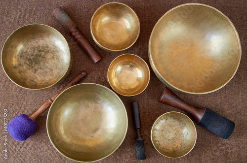 Top view of tibetan singing bowls with sticks on the dark background - music instruments for meditation  relaxation  yoga  massage  sound healing 