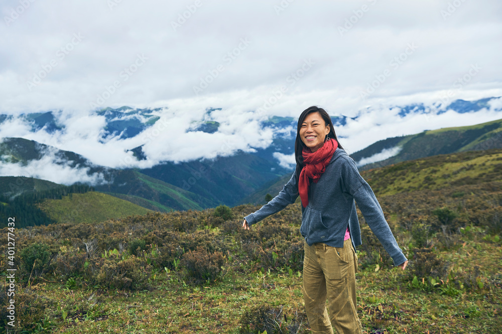 Happy ethnic female hiker in mountain valley Happy ethnic female hiker in mountain valley