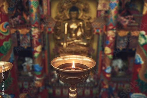 High angle of burning candle in candlestick lit for prayer in holy place in Buddhist temple in China photo