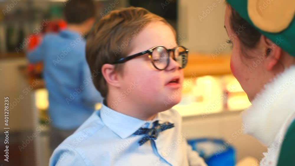 A boy with down syndrome wearing glasses talks to a gnome teacher. Communication in art therapy of children's play. A boy with down syndrome wearing glasses talks to a gnome teacher. Communication in art therapy of children's play.
