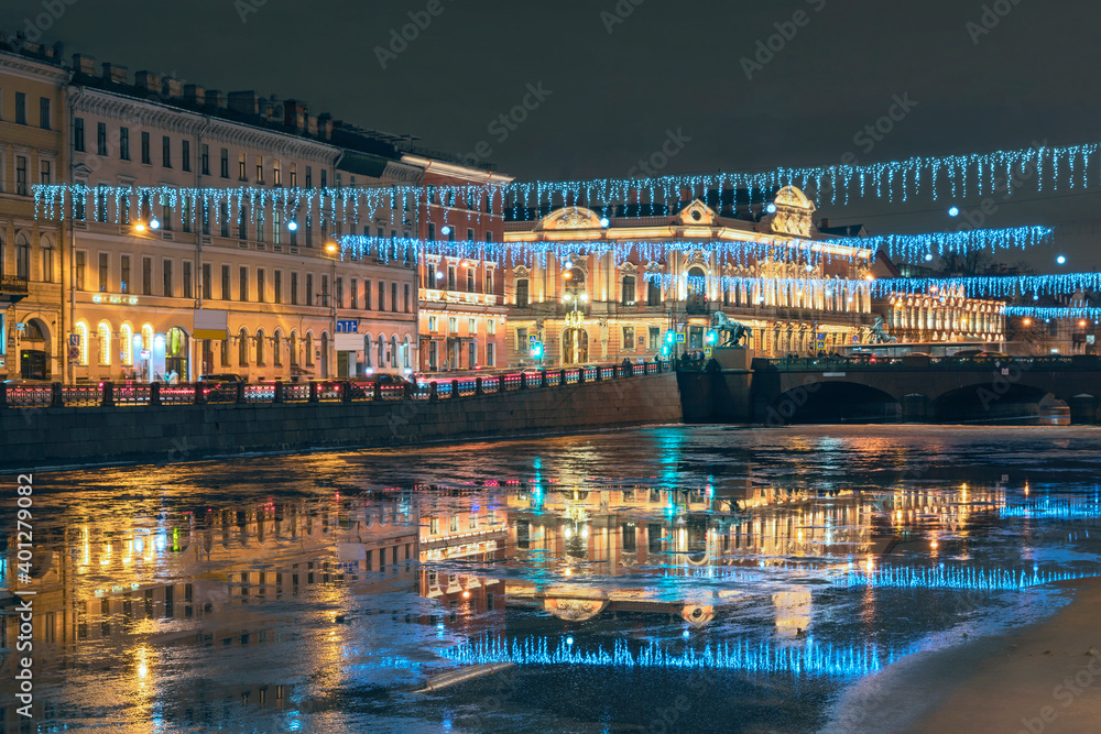 beautiful festive illumination along the embankment and the bridge, reflected in the water of the Fontanka River. St. Petersburg. Russia