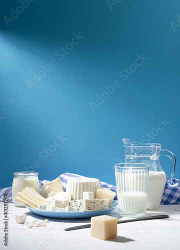 Dairy products on white wood base and blue background with  copy space. Vertical format. photo