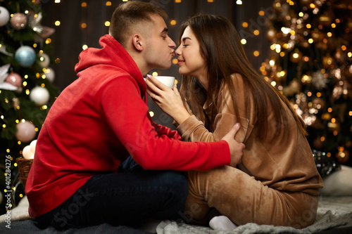 loving couple kissing on the Christmas tree backgroud at home