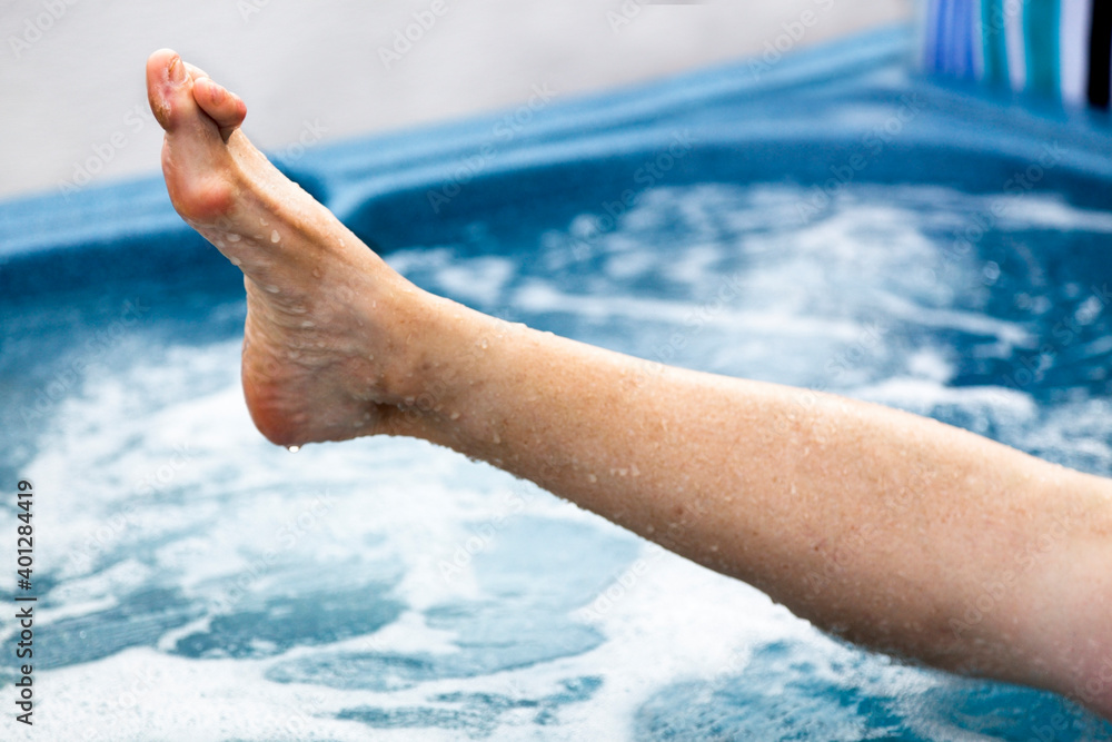 Foto de Female feet in hot tub with deformities bunions and hammertoes