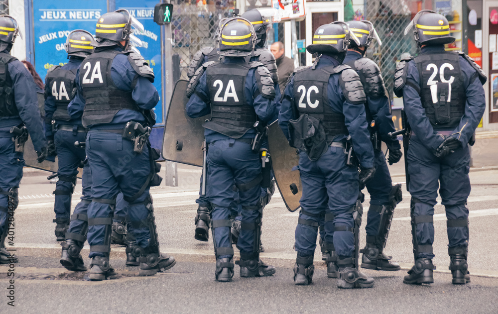 policiers anti émeute en tenue de protection face à des manifestants en attente d'intervention policiers anti émeute en tenue de protection face à des manifestants en attente d'intervention