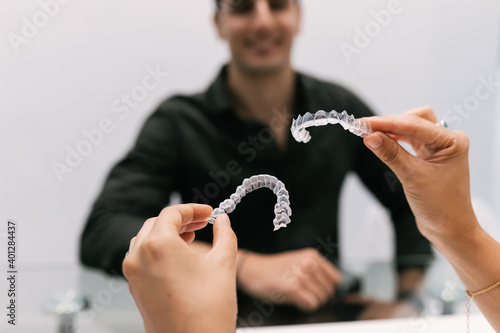 Dentist's hands showing invisible orthodontics to your patient