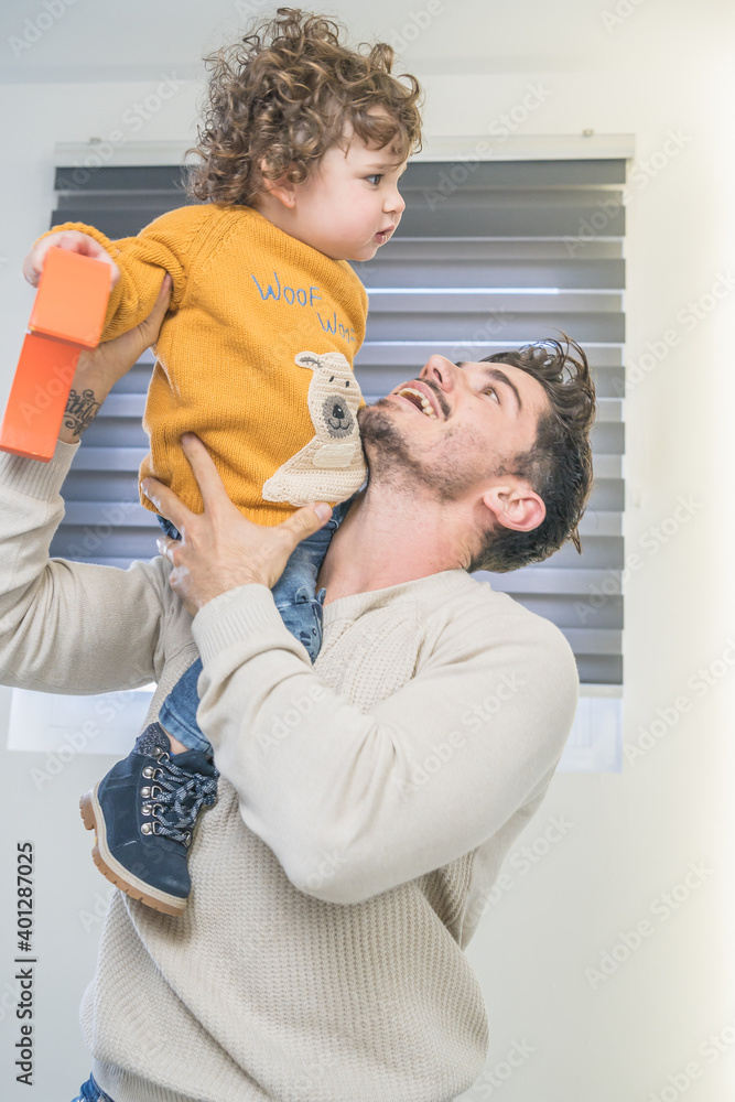 Fototapeta premium Dad playing with his son with yellow sweater