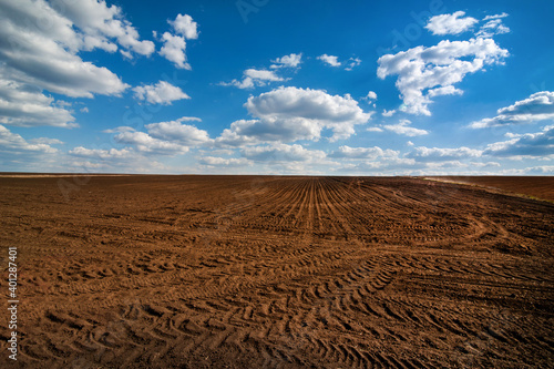 field prepared for sowing and tracks of tractor tires, beautiful blue sky