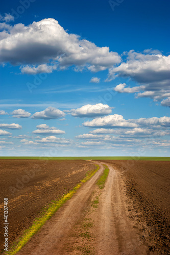 plowed field with dirt road in spring