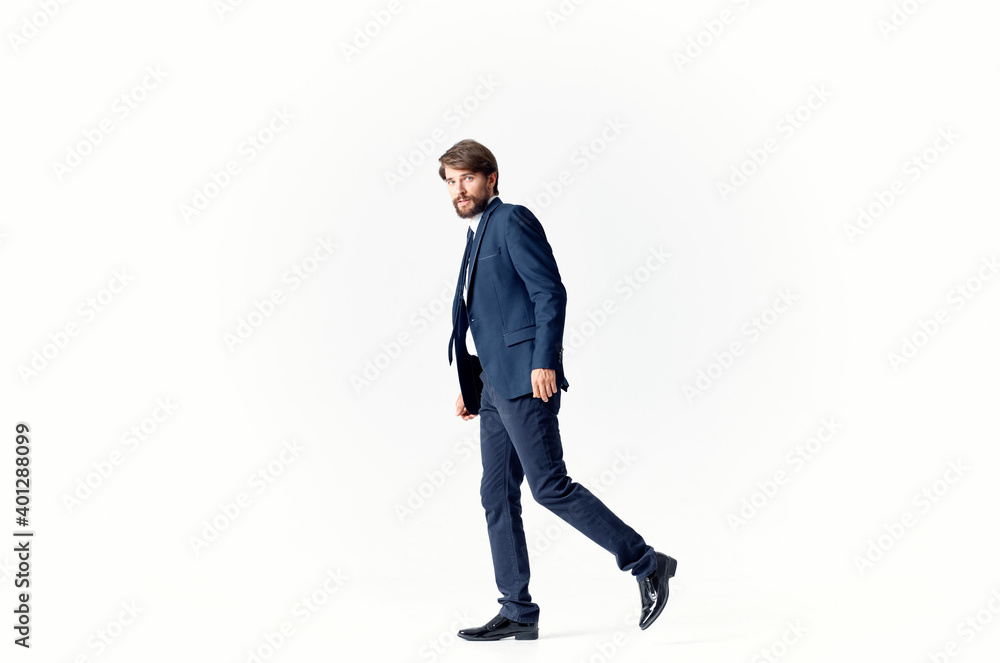 a man on a light background walks and jumps to the side in full growth business finance a man on a light background walks and jumps to the side in full growth business finance
