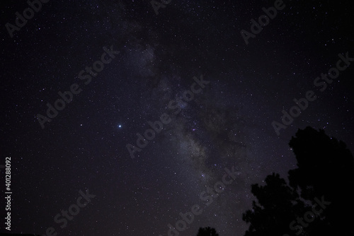 From below of dark night sky with glowing stars and Milky Way galaxy