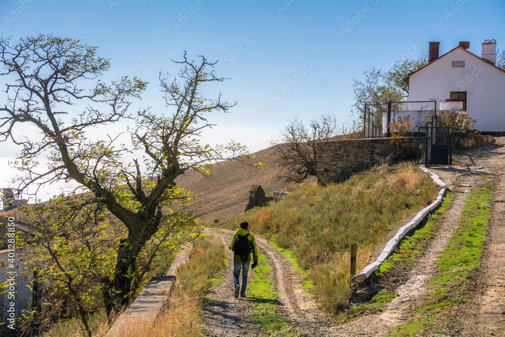 A tourist walks past the house of the lighthouse keeper in the Republic of Crimea